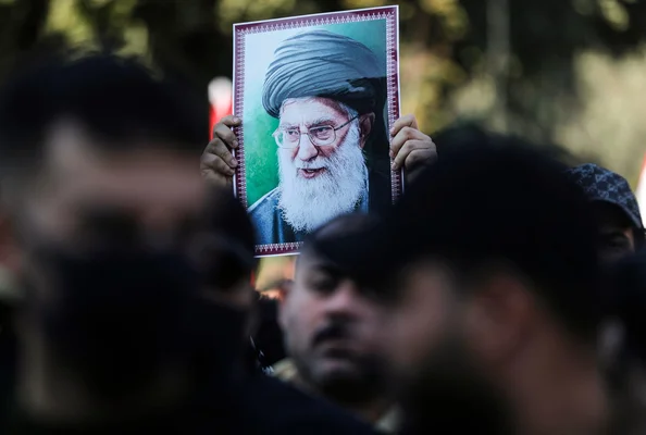 Portrait d'Ali Khamenei tenu lors d'un rassemblement, illustrant le soutien populaire.