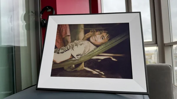 Le cadre Aura Ink affiche une photo d'un garçon souriant dans un hamac.