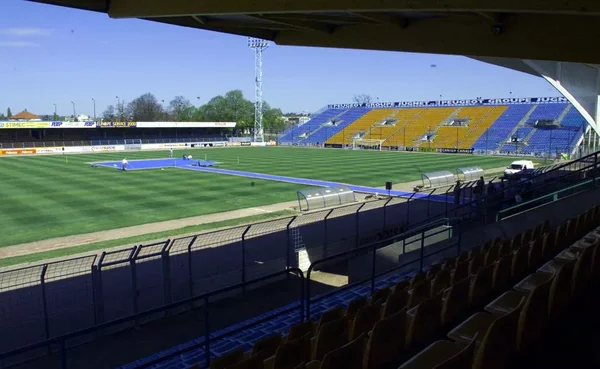 Stade du FC Gueugnon, vide, avec ses couleurs bleu et jaune.