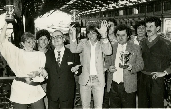 Le groupe Cookie Dingler pose avec trois trophées sous une arche, à l'occasion des 30 ans du tube « Femme libérée ».