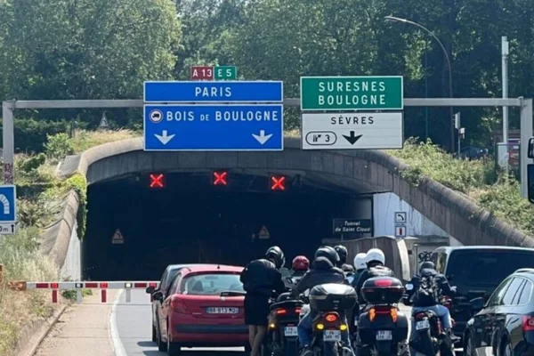 Véhicules à l'arrêt à l'entrée du tunnel de Saint-Cloud, sous les panneaux de signalisation.