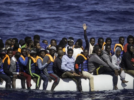 Migrants en détresse sur un canot pneumatique en Méditerranée, symbole des traversées meurtrières depuis la Libye.