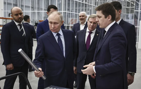 Visite d'oligarques russes dans une usine, illustrant leurs liens avec l'industrie lourde.