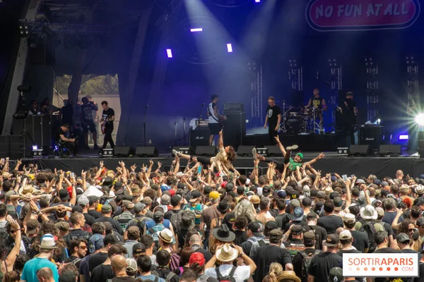 Le groupe No Fun At All en concert au Hellfest 2026, avec des fans surfant sur la foule sous une lumière bleue.