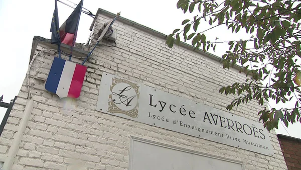Façade du lycée Averroès à Lille, avec son enseigne et les drapeaux français.