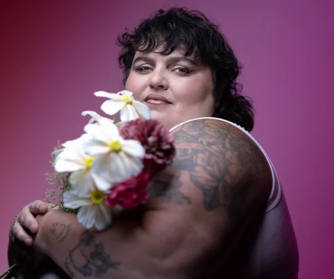 Barbara Butch posant avec un bouquet de fleurs.