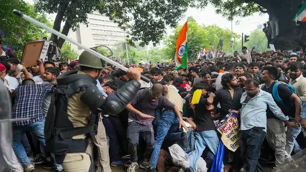 Un policier charge des manifestants près de la rue du Parlement à Delhi.