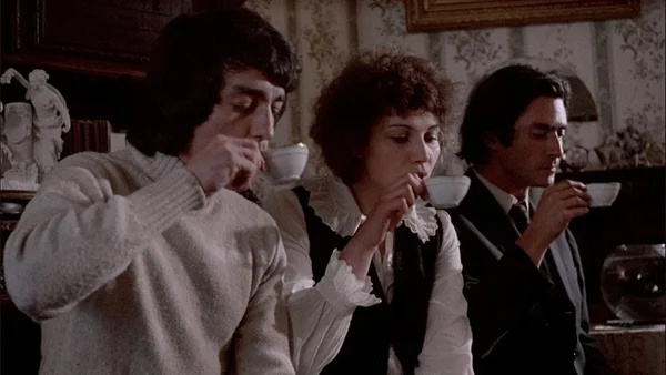 Scène du film « Happy Birthday » : trois personnages attablés dans une atmosphère intimiste.