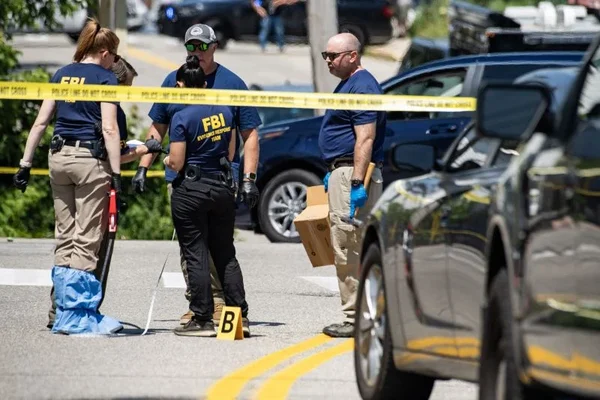 Des agents du FBI examinant la scène de l'incendie devant le bâtiment fédéral à New York, avec du ruban de police jaune.