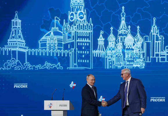 Poignée de main lors d'un événement économique à Moscou, en présence d'hommes d'affaires russes.