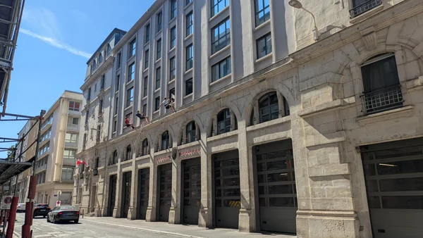 Des militants politiques grimpent sur la façade d'une caserne de pompiers à Lyon lors de l'altercation entre LFI et Uni.