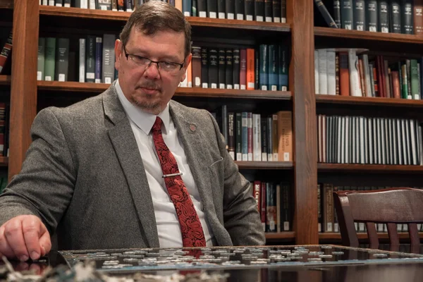 Douglas Wilson, pasteur et figure de la nouvelle droite américaine, jouant à un jeu de société dans une bibliothèque.