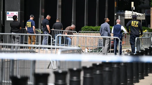 Des agents du FBI et de l'ATF derrière un périmètre de sécurité devant un bâtiment fédéral à New York après l'attaque.