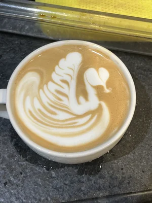 Un flat white orné d'un cygne en latte art, symbole de la culture café moderne.
