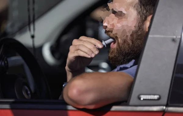 Un homme barbu souffle dans un éthylotest lors d'un contrôle routier.