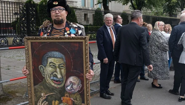 Semyon Skrepetsky avec sa caricature, entouré de personnes en tenue formelle.