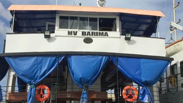 La passerelle du ferry 'MV BARIMA' avec ses bouées de sauvetage et ses bancs en bois.