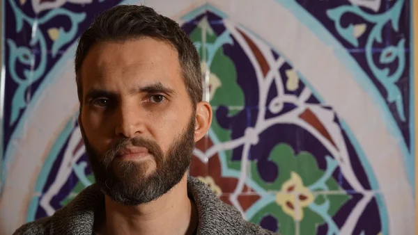 Ludovic-Mohamed Zahed, imam et homosexuel, devant un mur de carreaux géométriques.