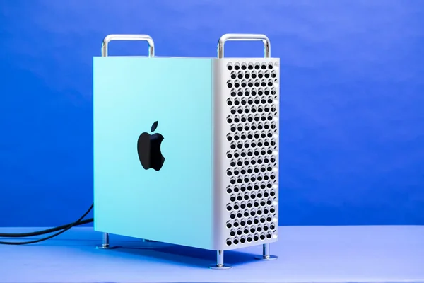 Apple Mac Pro tour avec panneau latéral bleu clair et treillis d'acier inoxydable, sur fond bleu.