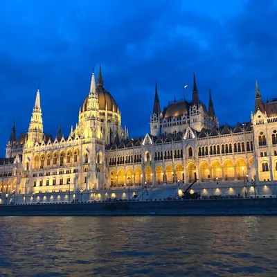 Le Parlement hongrois illuminé la nuit, vu depuis le Danube