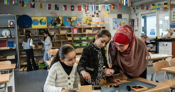Une enseignante du Groupe Scolaire Averroès aide des élèves avec des blocs éducatifs en classe.