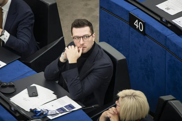 Jordan Bardella lors d'une séance parlementaire, visiblement pensif.