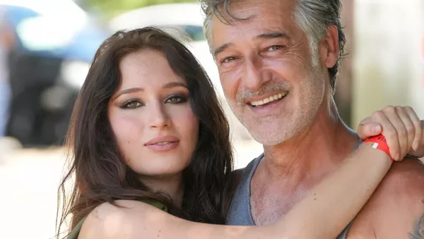 Stéphane Blancafort et Catherine Davydzenka enlacés, souriant à l'extérieur.