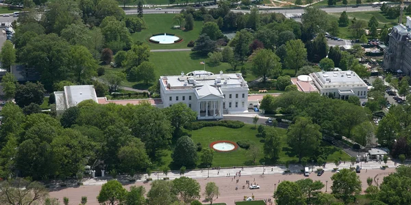 Vue aérienne de la Maison-Blanche à Washington, D.C., montrant son architecture néoclassique entourée de verdure.