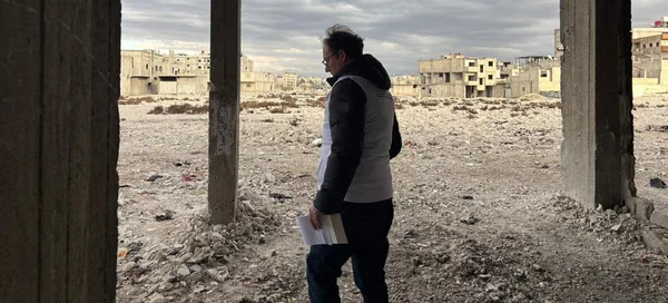 Un homme debout parmi les ruines d'un quartier dévasté de Souweïda, après les violences meurtrières de juillet 2025.