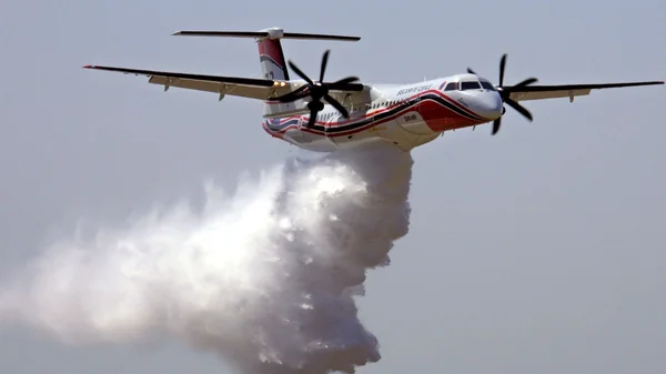 Un Bombardier Dash 8 Q400MR déverse un produit retardateur lors d'un exercice ou d'une intervention.