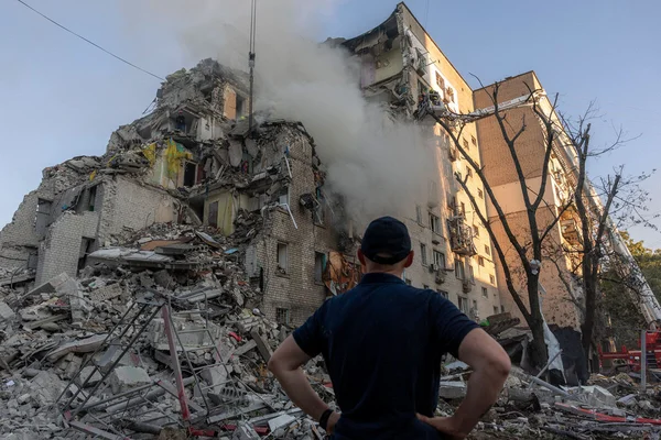 Un homme observe un immeuble résidentiel endommagé par une attaque de missiles à Kiev.
