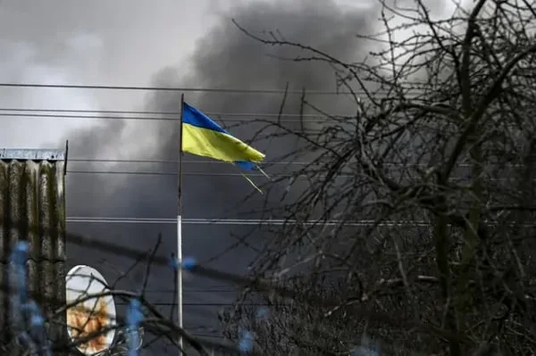 Drapeau ukrainien avec de la fumée noire s'élevant à Kiev lors de l'alerte aérienne.