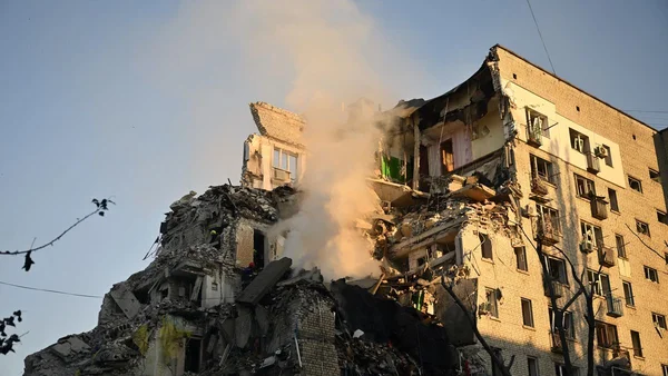Immeuble résidentiel gravement endommagé après une attaque à Kiev, avec une section effondrée et de la fumée.