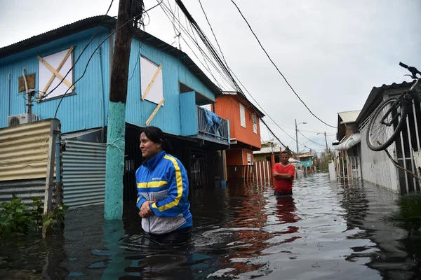 Une femme et un homme dans les eaux de crue après l'ouragan Maria à Porto Rico