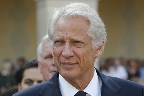 Dominique de Villepin en extérieur, regard sérieux.