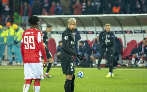 Kylian Mbappé en action lors d'un match professionnel sous la pluie.