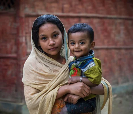 Jeune fille rohingya avec un enfant dans un camp de réfugiés.