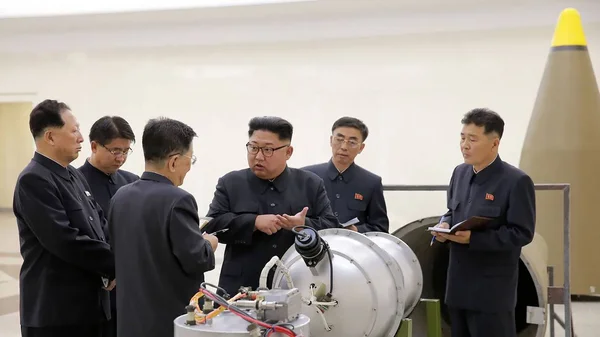 Des responsables nord-coréens inspectant un dispositif présenté comme une bombe à hydrogène lors du sixième essai nucléaire.