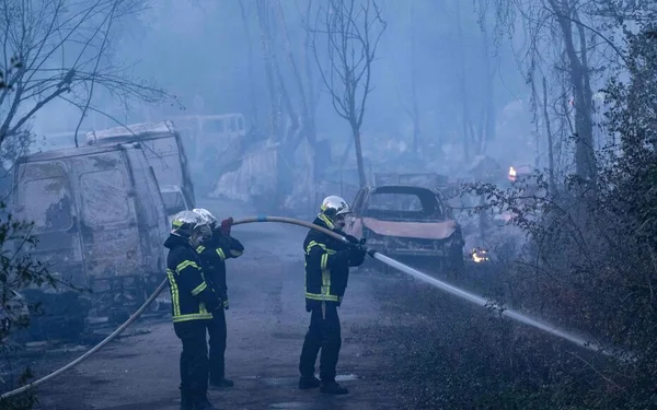 Trois pompiers luttent contre l'incendie qui a ravagé un bidonville et détruit 10 hectares de végétation à Nantes.