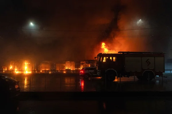 Un camion de pompiers devant un bâtiment en flammes à Kiev lors de l'alerte aérienne.