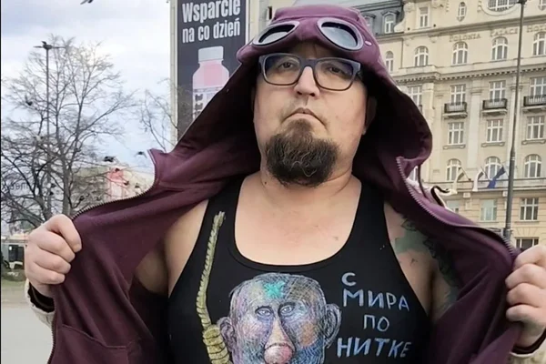 Semyon Skrepetsky devant l'hôtel Polonia Palace, montrant son t-shirt anti-Poutine.