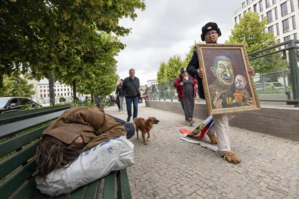 Un homme présentant une caricature de Poutine dans une rue en Pologne.