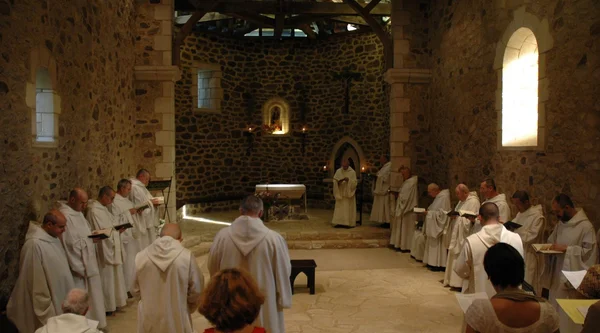 Des moines bénédictins en prière dans une chapelle.