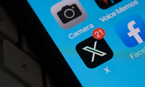 Écran de smartphone montrant l'icône de l'application X avec une notification non lue.