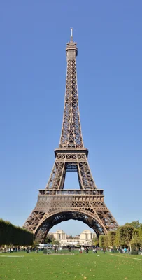 La tour Eiffel vue de face depuis le Champ-de-Mars par une journée ensoleillée.