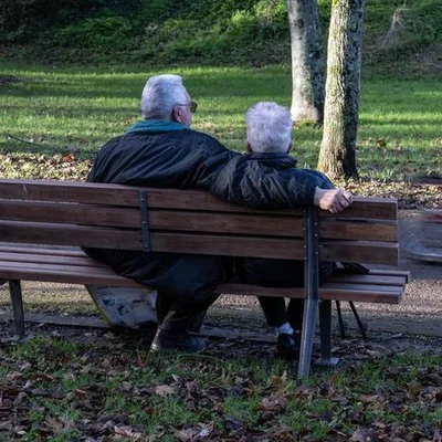 Deux retraités sur un banc dans un parc, illustrant le temps passé à la retraite.