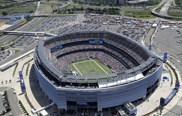 Le MetLife Stadium bondé pendant un match, entouré de son vaste complexe autoroutier.