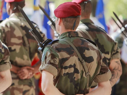 Des soldats en béret rouge lors d'une cérémonie militaire.