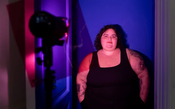 Barbara Butch, artiste et DJ, dans un jeu de lumières bleues et roses.