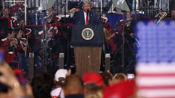 Donald Trump au pupitre présidentiel, le poing levé, devant un orchestre militaire lors des festivités du 250e anniversaire.